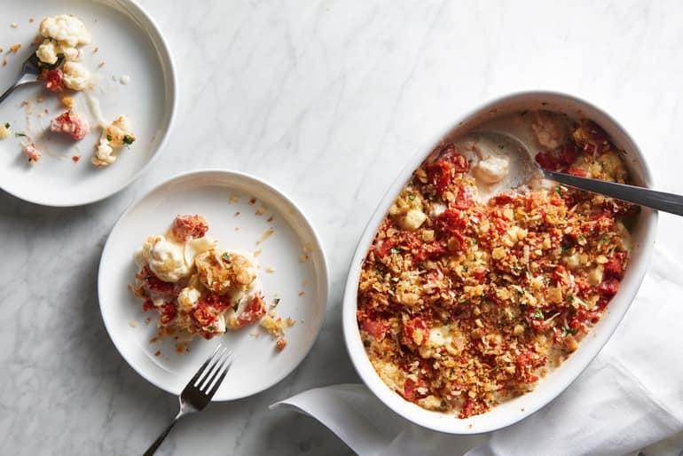 Overhead view of a dish of cheesy cauliflower gratin topped with bread crumbs, made with Muir Glen Organic Fire Roasted Whole Tomato