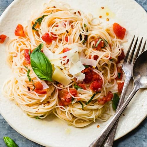Angel hair pasta garnished with tomato and basil
