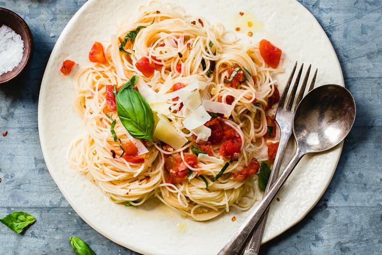 Angel hair pasta garnished with tomato and basil