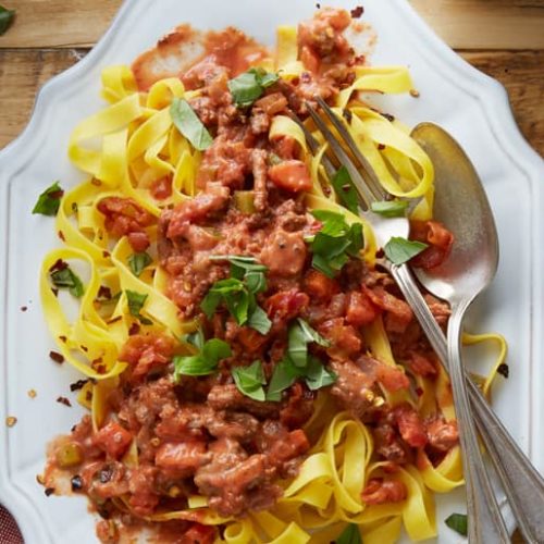 Tagilatelle with easy rustic bolognese garnished with fresh herbs