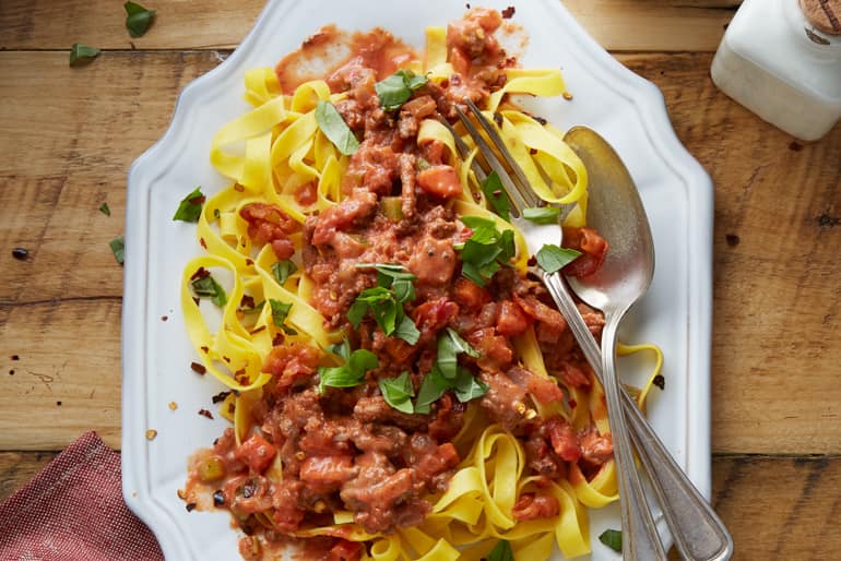 Tagilatelle with easy rustic bolognese garnished with fresh herbs