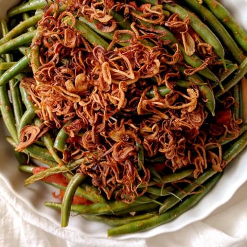 Overhead view of a dish of Lebanese green beans made with Muir Glen Organic Stewed Tomatoes topped with crispy shallots.